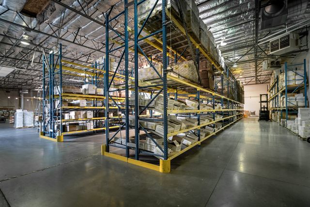 Fulfillment warehouse with tall blue and yellow pallet racking full of boxed inventory