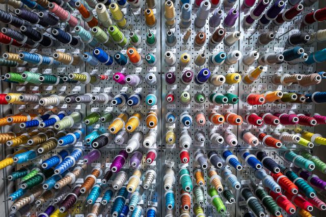 Pegboard wall of embroidery thread cones in dozens of colors