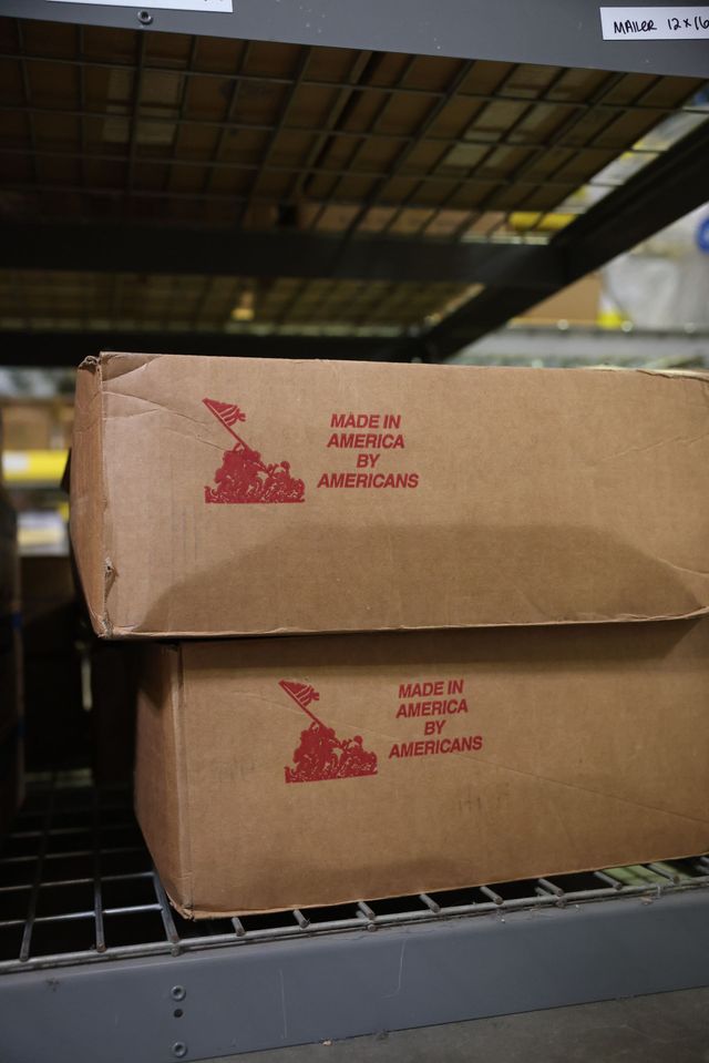 Two cardboard cartons stamped Made in America by Americans on a warehouse shelf