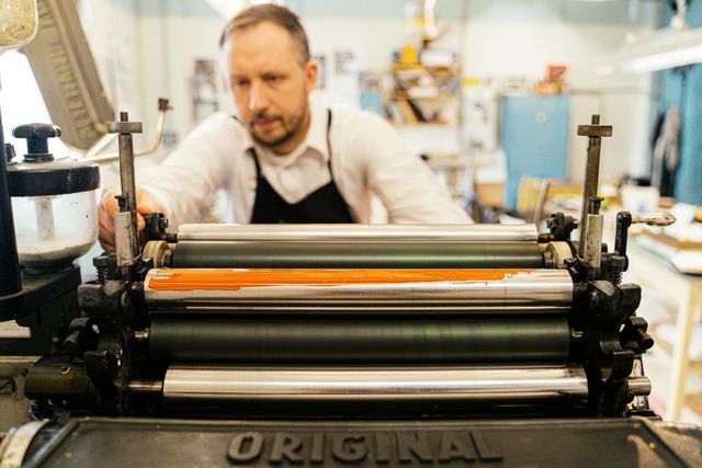 Printer working at a vintage printing press